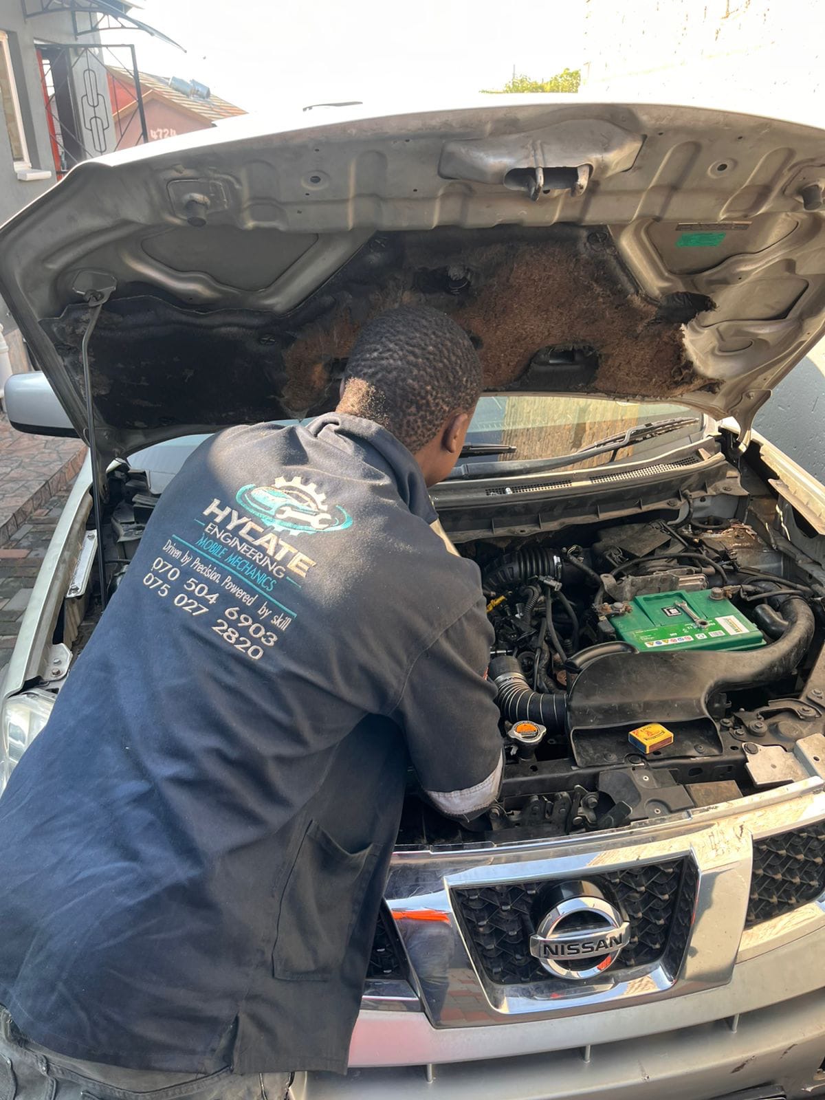 Hycate mechanic working on an engine bay